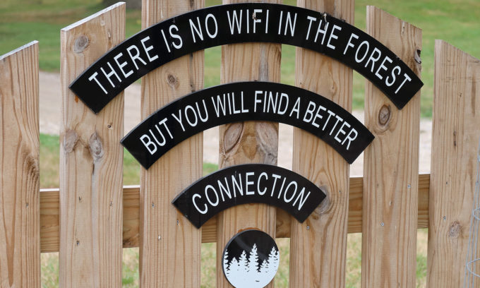 Black and white sign saying "There is no wifi in the forest but you will find a better connection"